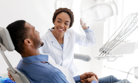 Female dentist turning on lamp before treatmentの写真素材