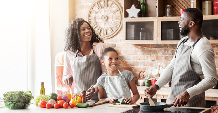 Happy black family of three laughing at kitchen