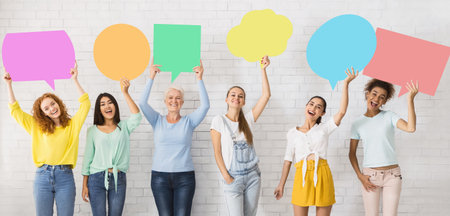 Diverse Women Holding Colorful Speech Bubbles Next To White Wall