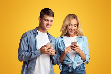 Curious boyfriend peeking into girlfriends smartphone, trying to read messagesの写真素材