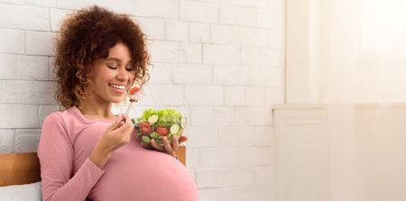 Pregnancy meal plan. African-american woman eating fresh vegetable salad