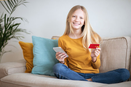 Teen Girl Making Online Purchase With Smartphone and Credit Cardの写真素材