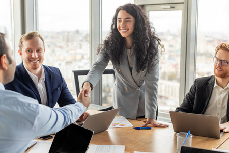 Businesswoman Shaking Hands With Colleague in Modern Office Meeting