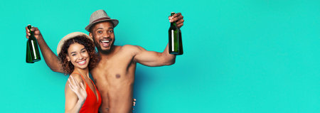 Happy Couple Holding Bottles on Turquoise Backgroundの写真素材