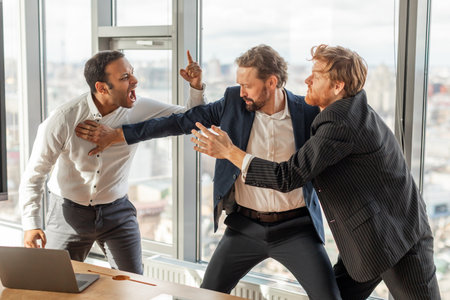 Three Businessmen Involved in Intense Argument in a Modern Officeの写真素材
