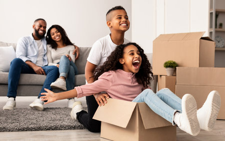 Happy African American family celebrating moving day in new apartmentの写真素材
