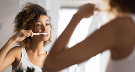African American Girl Brushing Teeth With Toothbrush In Bathroom, Panoramaの写真素材