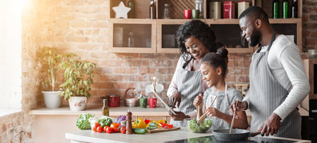Mommy, daddy and daughter reading recipe on tablet at kitchen