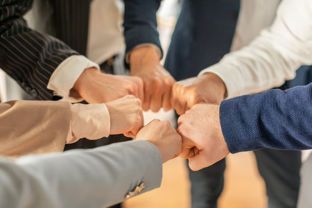 Businesspeople Bump Fists in Circle During Meeting