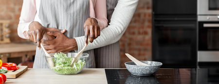 Cropped image of married couple cooking together at kitchenの写真素材