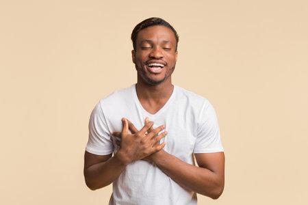 Touched Black Man Pressing Hands To Chest Standing, Yellow Background