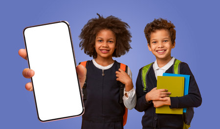 Two Smiling Children Holding Books and Smartphone With White Screen