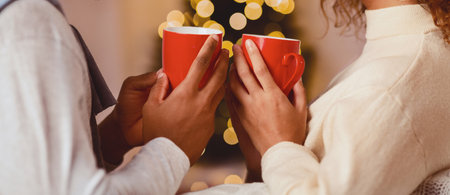 Young afro couple drinking hot chocolate on Christmas eve