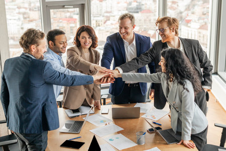 Diverse Business Team Placing Hands Together in Modern Office Meeting