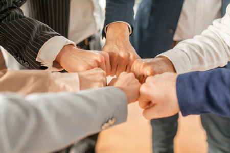 Business Professionals Bump Fists in Circle During Meeting