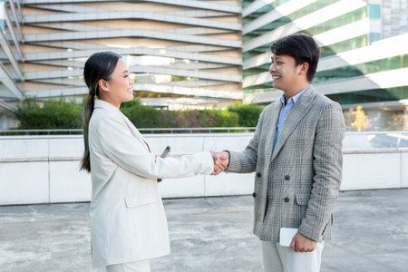 Business Professionals Engaging in a Warm Handshake Outsideの写真素材