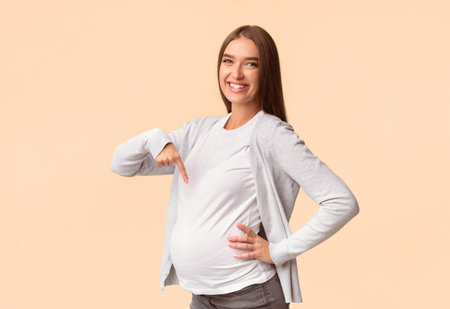 Pregnant Girl Pointing Finger At Belly Posing Over White Background