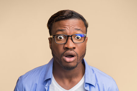 Surprised African American Guy Looking At Camera Posing, Yellow Backgroundの写真素材