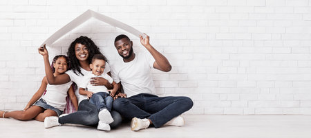 Beautiful Black Family Holding Cardboard Roof Dreaming Of New Homeの写真素材
