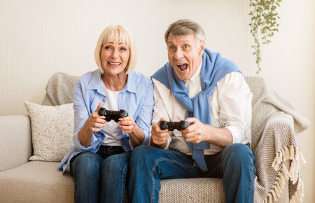 Overjoyed mature couple playing video games at home