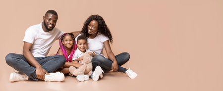 Portrait of happy black family with children sitting on floorの写真素材