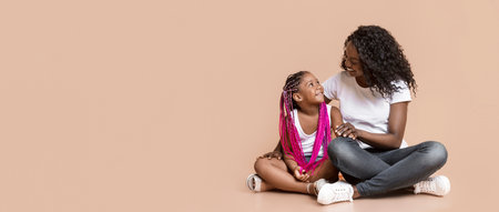 Portrait of smiling afro mom and her adorable little daughterの写真素材