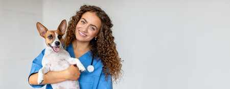 Happy vet holding terrier in clinic, copy spaceの写真素材
