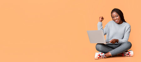 Young Woman Celebrating Success While Working on Laptopの写真素材