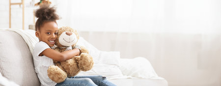 Happy Young Girl Cuddling A Soft Brown Teddy Bearの写真素材