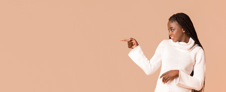 Happy black woman pointing at empty spaceの写真素材