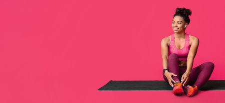 Happy fitness girl resting on yoga mat during trainingの写真素材