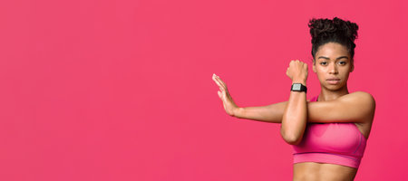 Young sporty girl doing physical exercises over red backgroundの写真素材