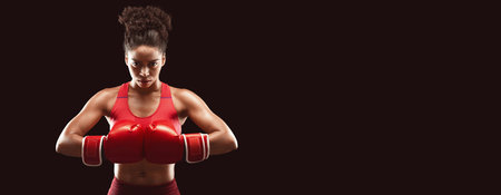 Woman professional boxer posing over black backgroundの写真素材