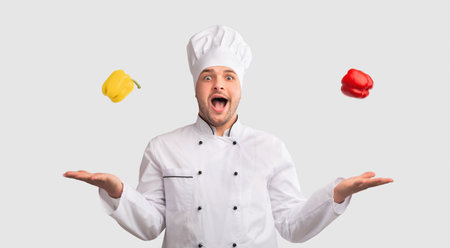 Cook Man Juggling Sweet Peppers Standing On White Backgroundの写真素材