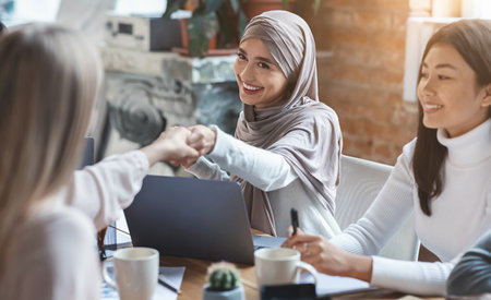 Two girls business colleagues shaking hands in officeの写真素材
