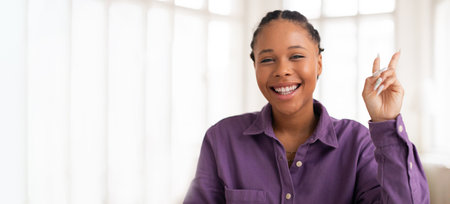 Young woman smiling while gesturing playfully indoors during daytime