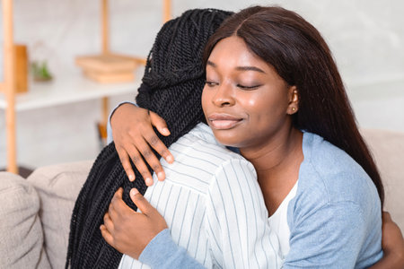 Fake Friendship. Indifferent Girl Rolling Eyes Hugging Crying Friend Sitting On Couch At Home. Selective Focusの写真素材