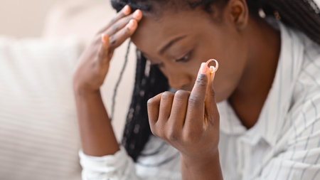Gold wedding ring in hand of upset black womanの写真素材