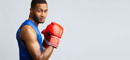 Portrait of confident black man wearing red boxing gloves