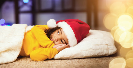 Little african girl pretending sleeping, waiting for Santa on floorの写真素材