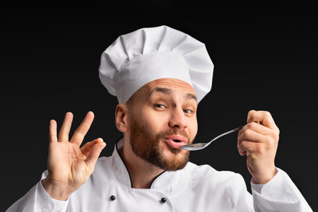 Chef Tasting And Approving Food Holding Spoon Posing In Studioの写真素材
