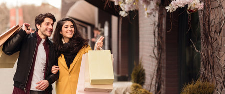 Young couple enjoying shopping together on city street in autumnの写真素材