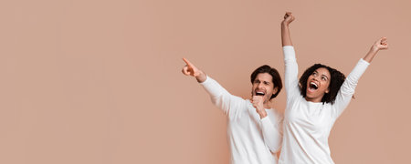 Multiracial couple dancing and singing together, having fun over yellow background