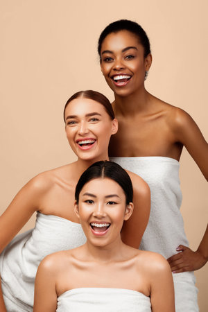 Three Girls In White Towels Posing Over Gray Background, Verticalの写真素材