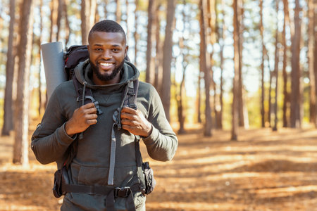 Happy black guy hiking with friends by countrysideの写真素材