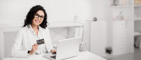 Smiling latin girl making donations using computerの写真素材