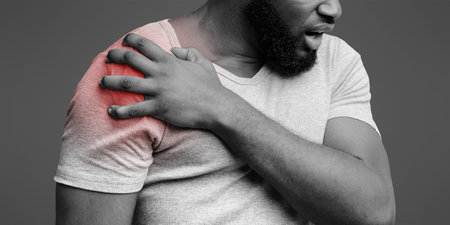 Young man suffering from pain in shoulder
