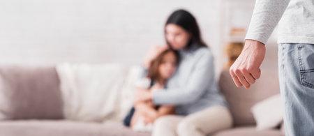 Domestic abuse. Scared woman and little girl suffering from fathers violenceの写真素材