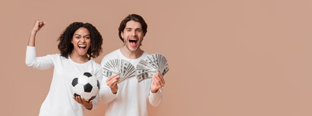 Overjoyed multiracial couple celebrating success with money cash and soccer ballの写真素材