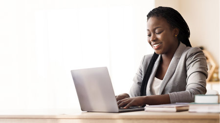 Black Millennial Businesswoman Using Laptop In Modern Office